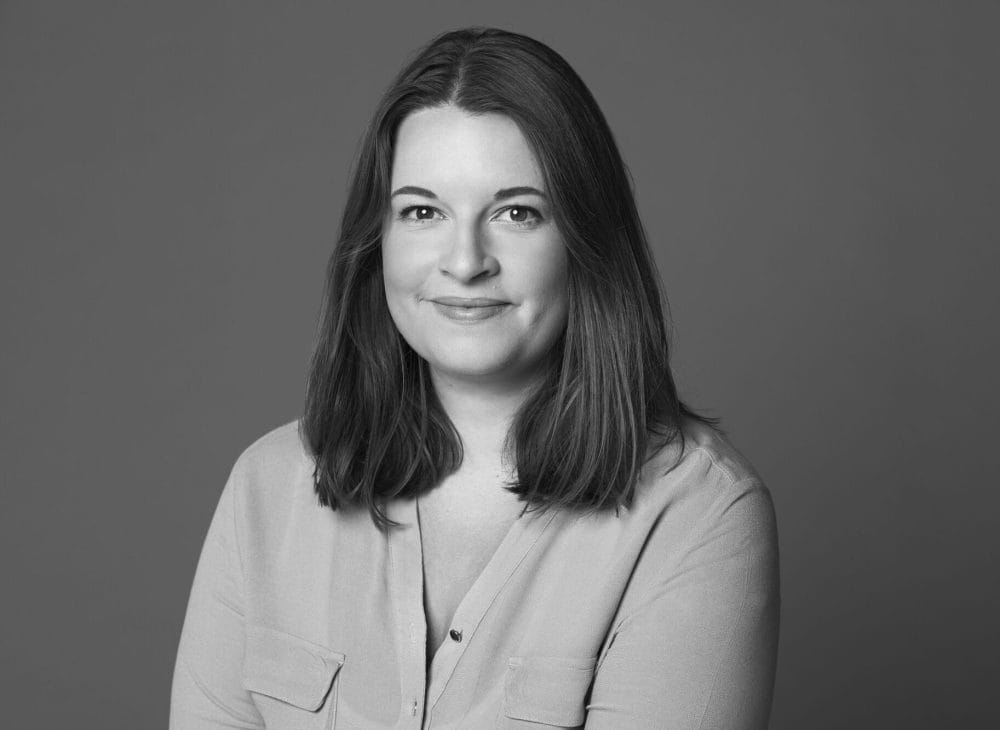 Porträtfoto von Linn-Sophie Löber – lächelnde Frau mit schulterlangem braunem Haar in hellem Oberteil